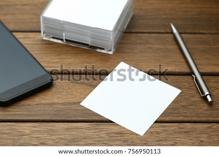 blank notepaper,pen,and smartphone on vintage wooden table