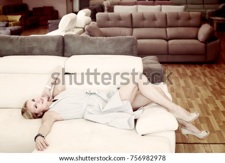 positive female is testing new sofa in furniture store