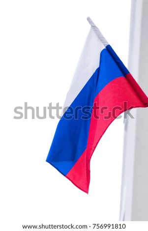 Russian flag hanging and developing close-up on a light blurred background.