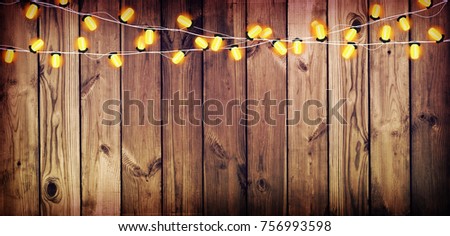 Holiday Lights on the old wooden background. The atmosphere of the holiday. Christmas party. New Year background.