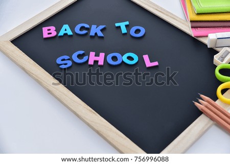 Education concept.  Back to school letters on the blackboard with school supplies on the background