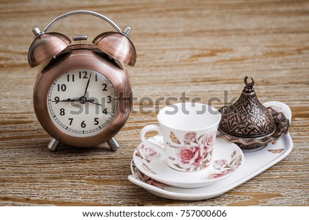 Turkish style coffee set served on a tray and an alarm clock