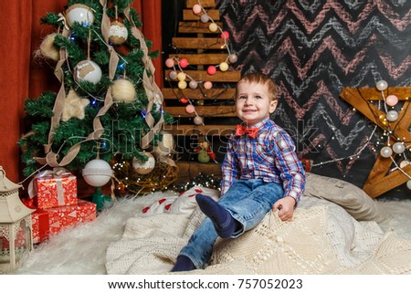 Small boy posing in a Christmas photo session. Studio shooting before the holidays