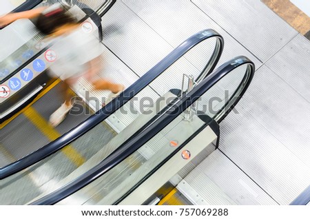 People on Escalator Motion Blurred, Top View. Abstract Blur Background of Moving Staircase