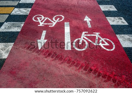 Two inverted road signs meaning cycle track on asphalt.