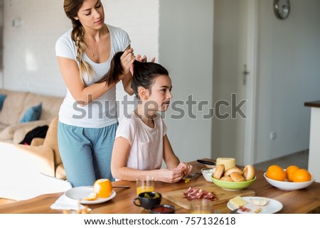 Mother doing daughters hair