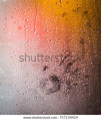 Print of hand on a wet fogged window with raindrops. closeup photo