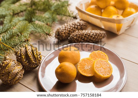 Tangerines with christmas tree branches on wooden background. Copy space.