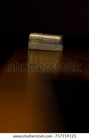 Old steel gasoline lighter on dark background. 