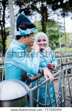 Lovely and playful couple enjoying life after married at park. Selective focus