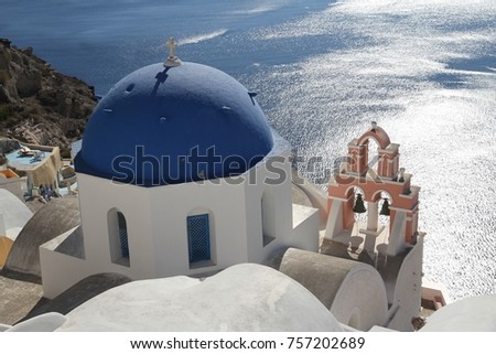 A view of colorful cubiform buildings on Santorini Island in Greece clinging to the cliff over the Aegean Sea.  Royalty-Free Stock Photo #757202689