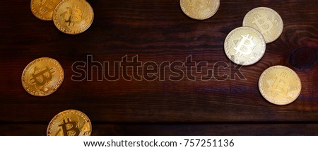 Golden physical bitcoins lies on dark wooden backgound, close up. High resolution photo. Cryptocurrency mining concept