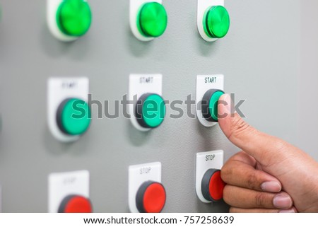 The hand pressing "start" switch on control board