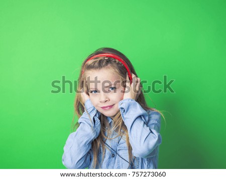 beautiful girl with red headphones in front of green background in the studio