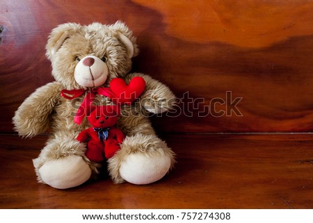 Cute dolls on a dark wood table and a loving red heart for thoughtful and creative ideas. The relevant background for romantic romance is the space for messages for Valentine to convey love
