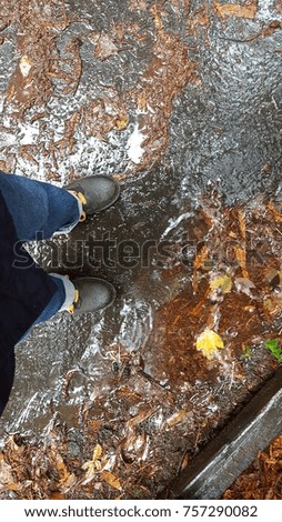 Looking down at purple boots in a puddle. Royalty-Free Stock Photo #757290082