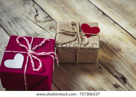 Two gift boxes and hearts. Wooden background.
