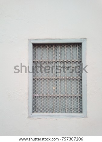 Decorative metal window on an old concrete wall