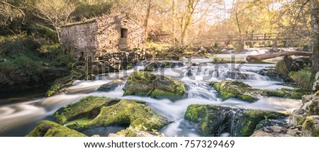 
Autumn on a mighty river with lots of water in Galicia or in Europe with a stone house or a cereal mill