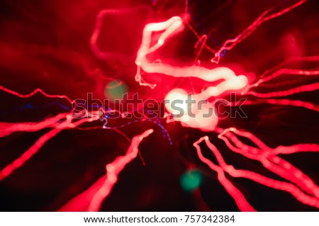 abstract blurred defocused texture. electric red lines on black background. energy bokeh with vivid bright lights.