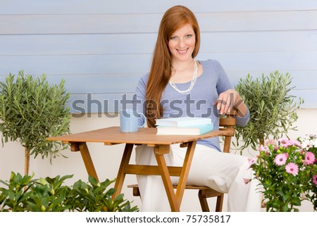 Summer terrace redhead woman drink cup coffee in garden