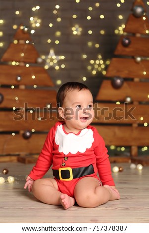 
Studio image of handsome baby boy over Christmas tree on Holiday theme