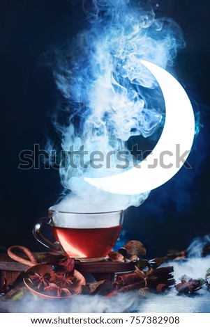 Cup of tea with dense steam and Moon crescent in conceptual astronomy scene. Dark food photography with smoke.