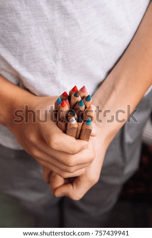 pencils in the hands of a teenager
