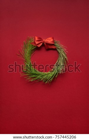 Creative concept photo of christmas wreath made of tree on red background.