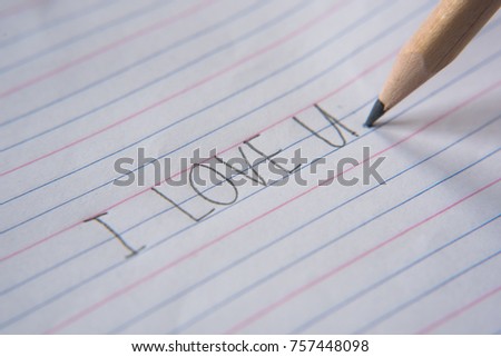 handwriting using pencil on a paper.write "i love you"