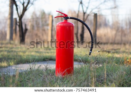 a fire extinguisher in an open area. blurred background