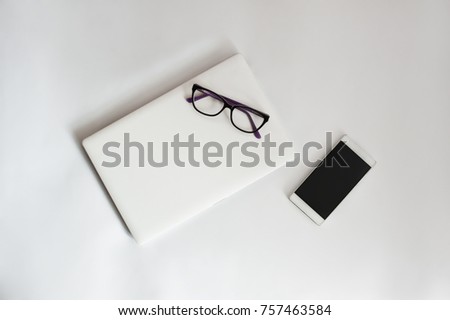 Concept of modern femail work place (background with notebook, smartphone, eyeglasses, glasses)