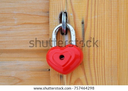 Iron red padlock in the shape of a heart. Close-up. Background.