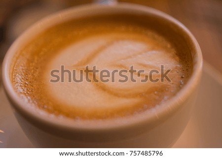 Flower on cappuccino cup, coffee with flower milk on top