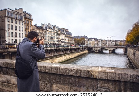 Tourist taking pictures of the central sights of Paris.