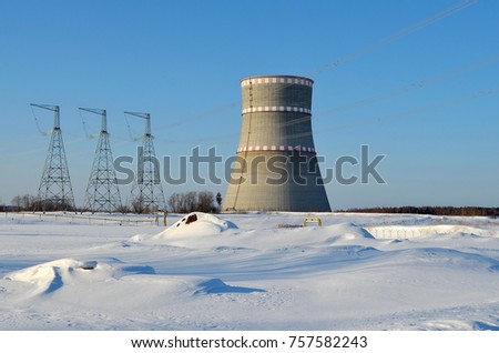 cooling tower on a background of blue clear sky and white snow, landscape