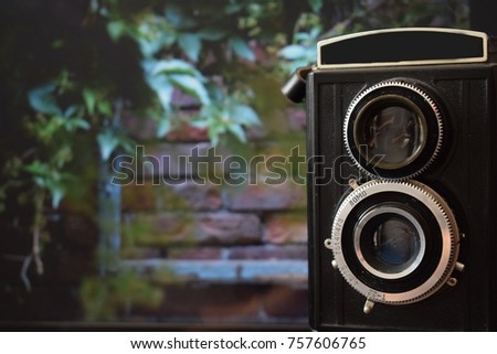 old camera with a brick wall in the background