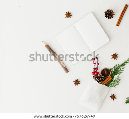 Notebook with Christmas decorations over white background