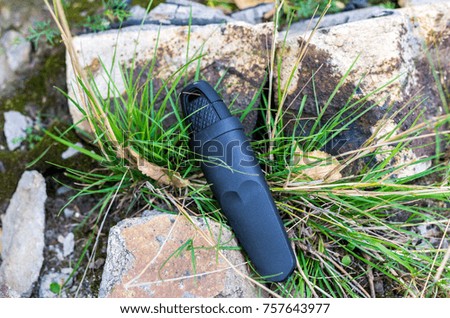 Scandinavian knife with a fixed blade in a plastic sheath. A photo on a background of nature.