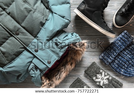 Women's fashion warm winter clothing and accessories - jacket, black leather high top sneakers, gloves and hat. Wish list or shopping overview concept. winter outfit. View from above. Flat lay
