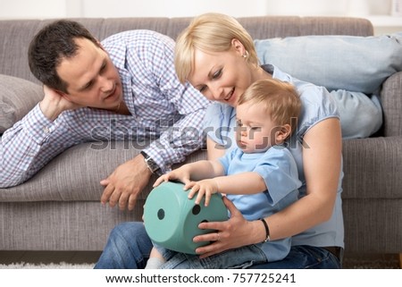 Happy family with one baby boy playing together at home.