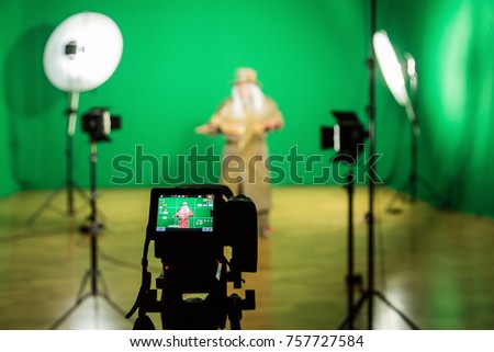 Shooting the movie on a green screen. The chroma key. Studio videography. Actor in theatrical costume. The camera and lighting equipment.