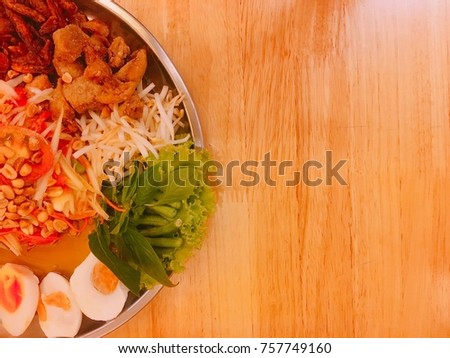 Papaya salad with eggs,crispy pork,fried fish and vegetable in a big tray already to serve. This is Thai traditional food.Concept for restaurant business and publish.Space for text design.Blur picture