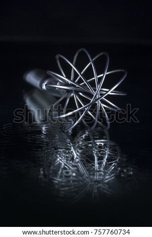 Stainless whisk on a black background