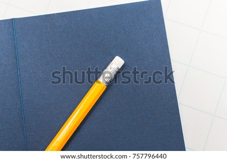 The yellow pencil is on the blue envelope writing business.