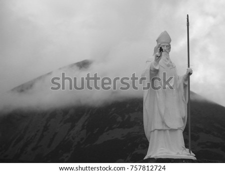 Statue of st. Patrick and st. Patrick hill in the clouds in the Ireland