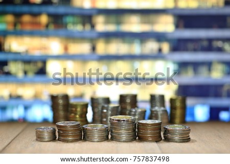 coin stack with blur office building background. Business, finance and saving concept.