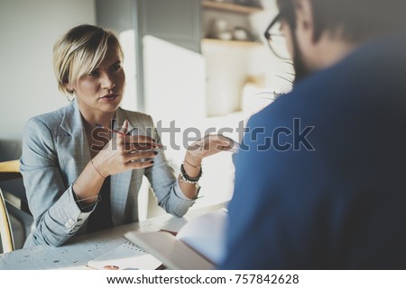 Coworkers working process at home.Young blonde woman working together with bearded colleague man at modern home office.People making conversation together.Blurred background.Horizontal Royalty-Free Stock Photo #757842628