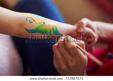 Artist is making butterfly picture on kids birhtday