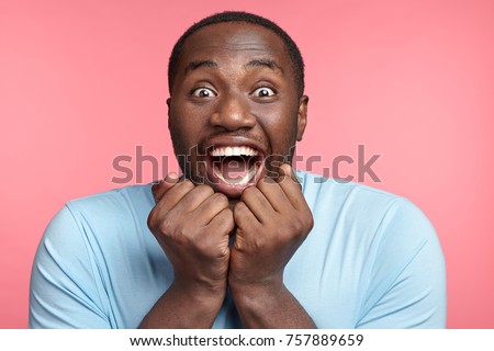 Excitement and amazement. Positive male says wow, stares at camera with eyes full of happiness, finds out about winning present in lottery, can`t believe his good luck, being excited and stunned